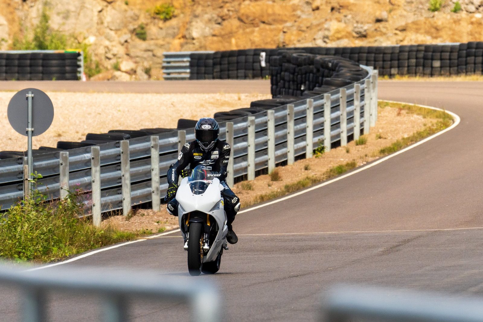 Ukkonen on track, exiting a corner between the barriers at speed.